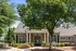 Charming residential building with elegant stone facade, lush landscaping, and welcoming front entrance.