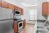 Contemporary kitchen with sleek stainless steel appliances, elegant wood cabinetry, and ample natural light.