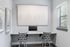 Modern home office nook with sleek desk, abstract artwork, and natural light from large window.