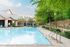 Inviting swimming pool area with lush greenery and comfortable seating, perfect for relaxation.