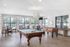 Bright and inviting recreation room featuring a billiards table, foosball, and ample seating with large windows offering scenic views.