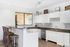 Modern kitchen with sleek white cabinetry, granite countertops, and cozy breakfast bar seating.