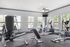 Bright and modern fitness center with diverse exercise equipment and large windows offering scenic views.