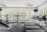 Bright and modern fitness center featuring treadmills and elliptical machines in a spacious, window-lined room.