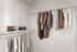 Elegant walk-in closet with neatly organized clothing and stylish storage options.