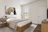 Bright and airy bedroom with modern decor, featuring a cozy bed, elegant artwork, and a sunlit window.