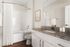 Elegant bathroom with granite countertop, modern fixtures, and a spacious bathtub with a clean, white design.