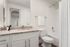 Elegant bathroom with sleek granite countertop, modern fixtures, and pristine white finishes, offering a serene retreat.