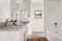 Modern bathroom featuring a sleek granite countertop, dual sinks, and a luxurious bathtub, enhanced by elegant fixtures and soothing artwork.