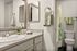 Bright and modern bathroom with elegant fixtures, chevron-patterned towels, and a refreshing floral shower curtain.