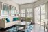 Bright and cozy living room with elegant decor, featuring a modern sofa, vibrant cushions, and large windows offering a serene outdoor view.