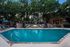 Luxurious swimming pool area with cozy seating and vibrant greenery, perfect for relaxation and outdoor entertainment.