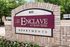Charming entrance sign of The Enclave at Bear Creek Apartments, surrounded by vibrant flowers and lush greenery, conveying a welcoming ambiance.