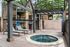 Charming outdoor terrace with a wooden pergola, featuring cozy lounge chairs beside a tranquil circular hot tub, ideal for relaxation.