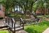 Charming apartment courtyard with a picturesque bridge, lush greenery, serene waterfall, and inviting pathways.