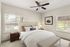Bright and cozy bedroom with elegant decor, featuring a plush bed, stylish lamps, and large windows with garden views.