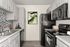 Contemporary kitchen with sleek black appliances, elegant cabinetry, and stylish mosaic backsplash.