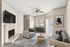 Chic living room with modern decor, featuring a cozy fireplace, elegant gray sofas, stylish coffee table, and large windows for natural light.