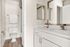 Elegant bathroom with modern fixtures, featuring a sleek countertop, stylish faucet, and warm wood flooring.