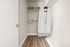 Spacious walk-in closet with elegant wood flooring, featuring hanging space and neatly organized shelves for stylish storage.