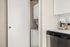 Modern apartment with sleek in-unit laundry and stylish coffee maker in kitchen.