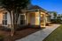 Charming apartment exterior with warm lighting, inviting front porch, and well-maintained landscaping at dusk.