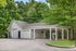 Charming suburban garage with dual entrances, nestled among lush greenery, featuring ample parking and a convenient vacuum station.