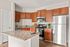 Contemporary kitchen with elegant granite countertops, stainless steel appliances, and rich wooden cabinetry offering a warm and inviting atmosphere.