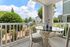 Charming patio with stylish dining set, offering serene views of lush greenery and a tranquil neighborhood backdrop.