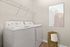 Modern laundry room with energy-efficient washer and dryer, elegant wall art, and stylish woven basket for storage.