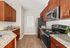 Modern kitchen with rich wood cabinets, sleek granite countertops, and stainless steel appliances, perfect for culinary enthusiasts.