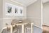 Chic dining room with modern round wooden table and four stylish chairs, enhanced by abstract wall art and warm beige walls.