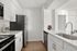 Sleek modern kitchen with stainless steel appliances, bright white cabinetry, and elegant countertops.