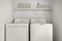 Modern laundry room with sleek washer and dryer, complemented by stylish storage baskets on a floating shelf.
