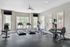 Modern fitness center with large windows, treadmills, exercise bike, and weight machines offering a bright and energizing workout environment.