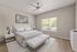 Bright and airy bedroom with a large window, modern decor, and cozy ambiance.