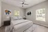Elegant bedroom with modern art, featuring a plush bed, stylish side tables, and natural light from large windows.