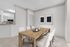 Bright and modern dining area featuring a rustic wooden table, elegant chairs, and minimalist artwork.