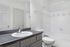 Bright and modern bathroom with sleek vanity, elegant faucet, and a tub with pristine white tile accents.