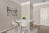 Elegant dining area featuring a modern white round table, chic beige chairs, and contemporary art on beige walls.