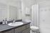 Modern bathroom with sleek countertop, elegant sink, white tiles, and a shower curtain for a fresh, bright look.
