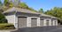 Charming residential garage units with modern design, nestled amidst lush greenery and vibrant trees.