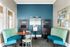 Chic co-working space with vibrant blue seating, modern communal tables, and sleek decor, perfect for productivity.