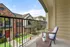 Charming balcony view of stylish townhouses with lush green landscaping, featuring a cozy seating area perfect for relaxation.
