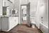 Elegant bathroom showcasing modern white cabinetry, sleek granite countertops, and a cozy bathtub, highlighted by rich wooden floors and ample natural light.