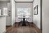 Bright dining area with elegant round table and four plush chairs, featuring large windows and contemporary artwork.