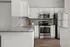 Modern kitchen with sleek granite countertops, stainless steel appliances, and elegant white cabinetry.