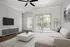 Bright and modern living room with elegant decor, featuring a cozy beige sofa, sleek white coffee table, and large windows offering abundant natural light.