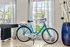 Modern interior with a stylish blue bicycle next to a large window, complemented by a chic vase with unique decor.