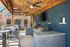 Chic outdoor kitchen with built-in grills under a stylish wooden pergola, perfect for entertaining.